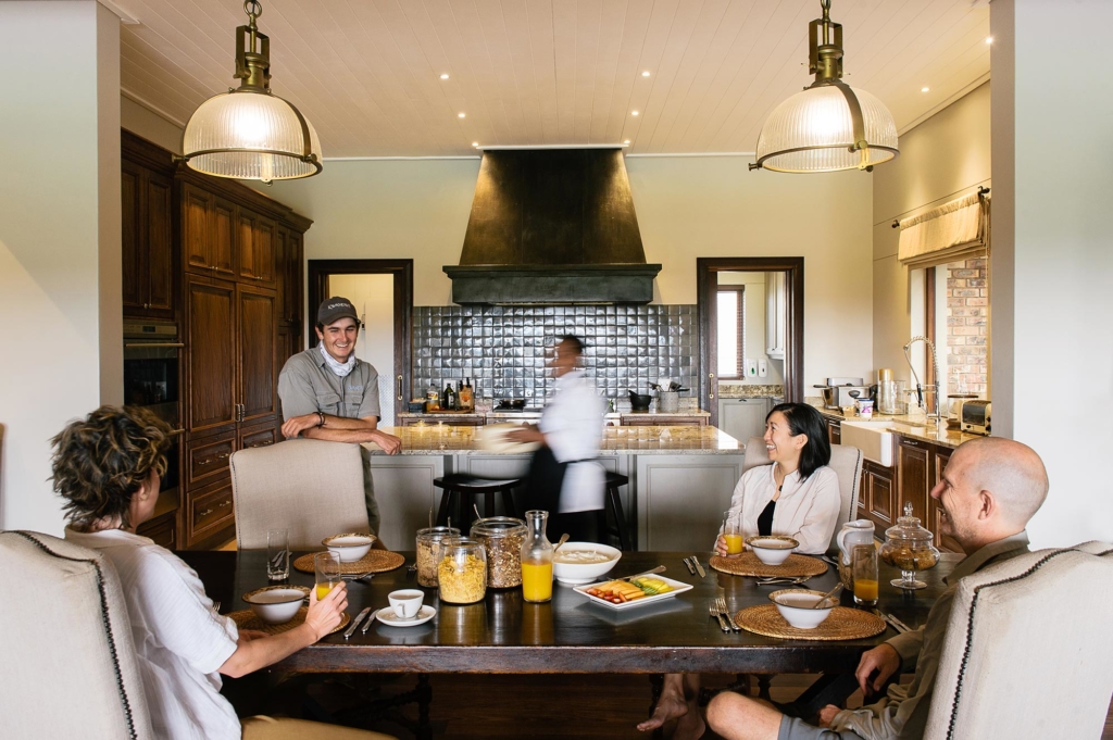 A group of people are enjoying breakfast in a modern kitchen setting.
