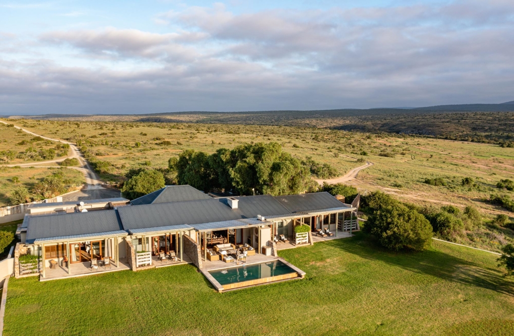A spacious modern house with a swimming pool set in a green landscape.