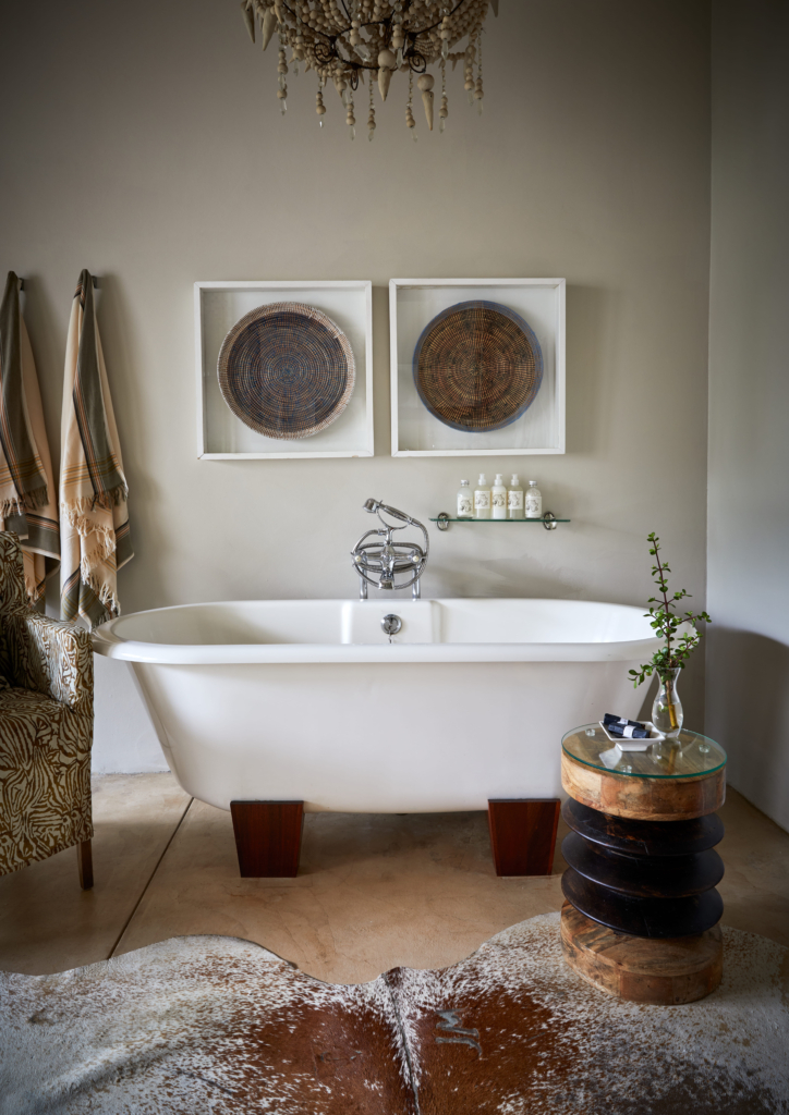 A modern bathroom featuring a freestanding bathtub, decorative artwork, and elegant furnishings.