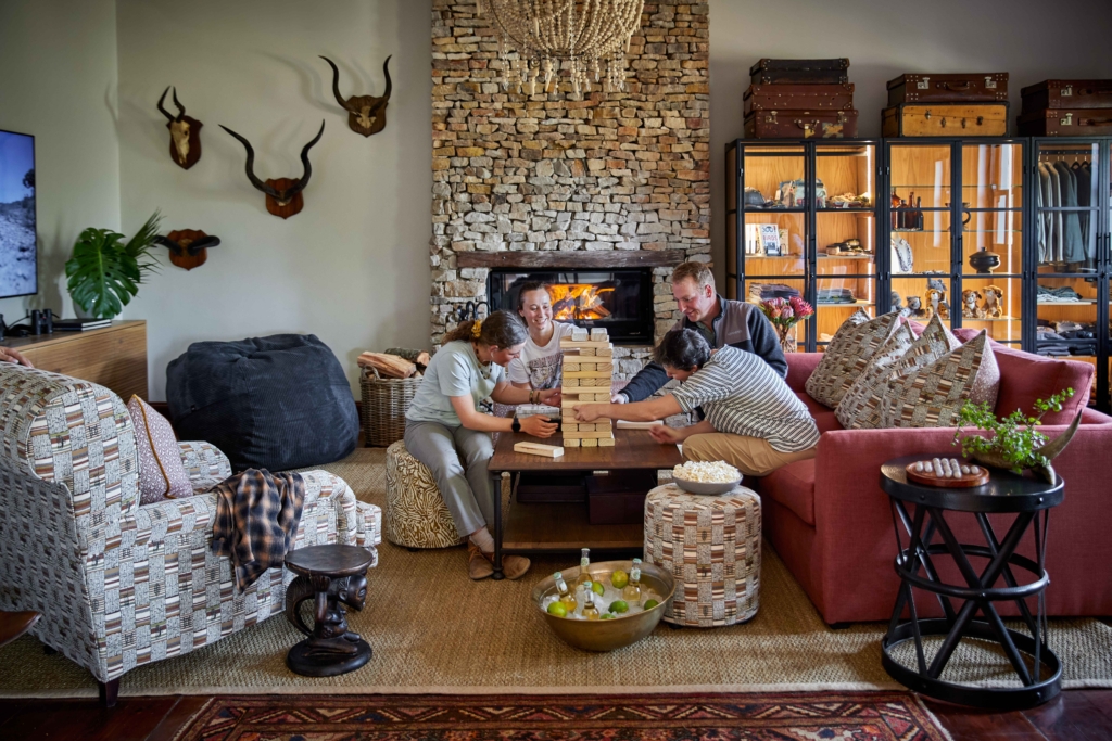 A group of four people are playing a game of Jenga in a cozy living room setting.
