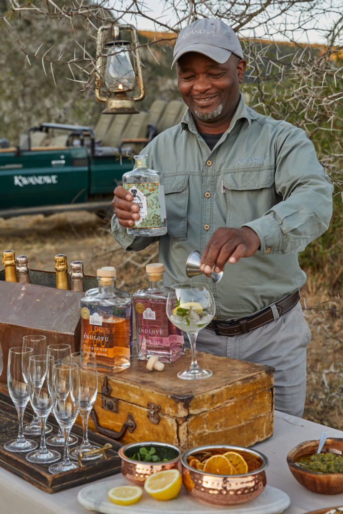 A man is preparing a cocktail at an outdoor bar setup.