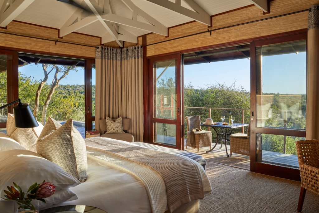 A cozy and modern hotel room featuring a bed and large windows with scenic views.