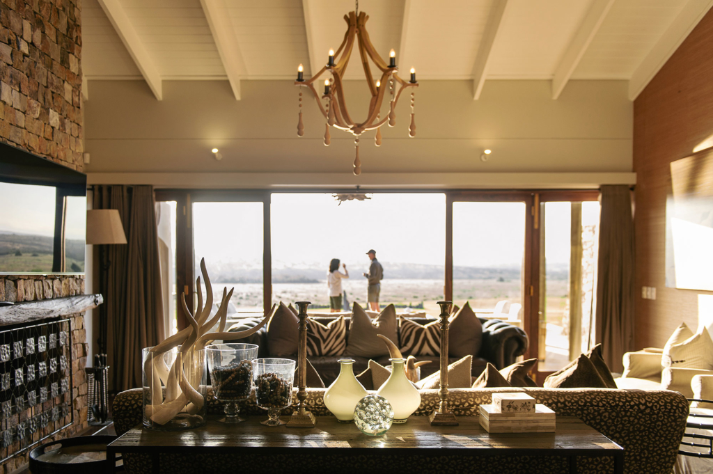 Interior of a modern living room featuring a table with decor and a view of people outside.